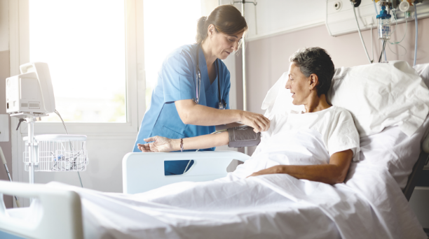 Pflegekraft, die einem Patienten im Krankenhaus hilft